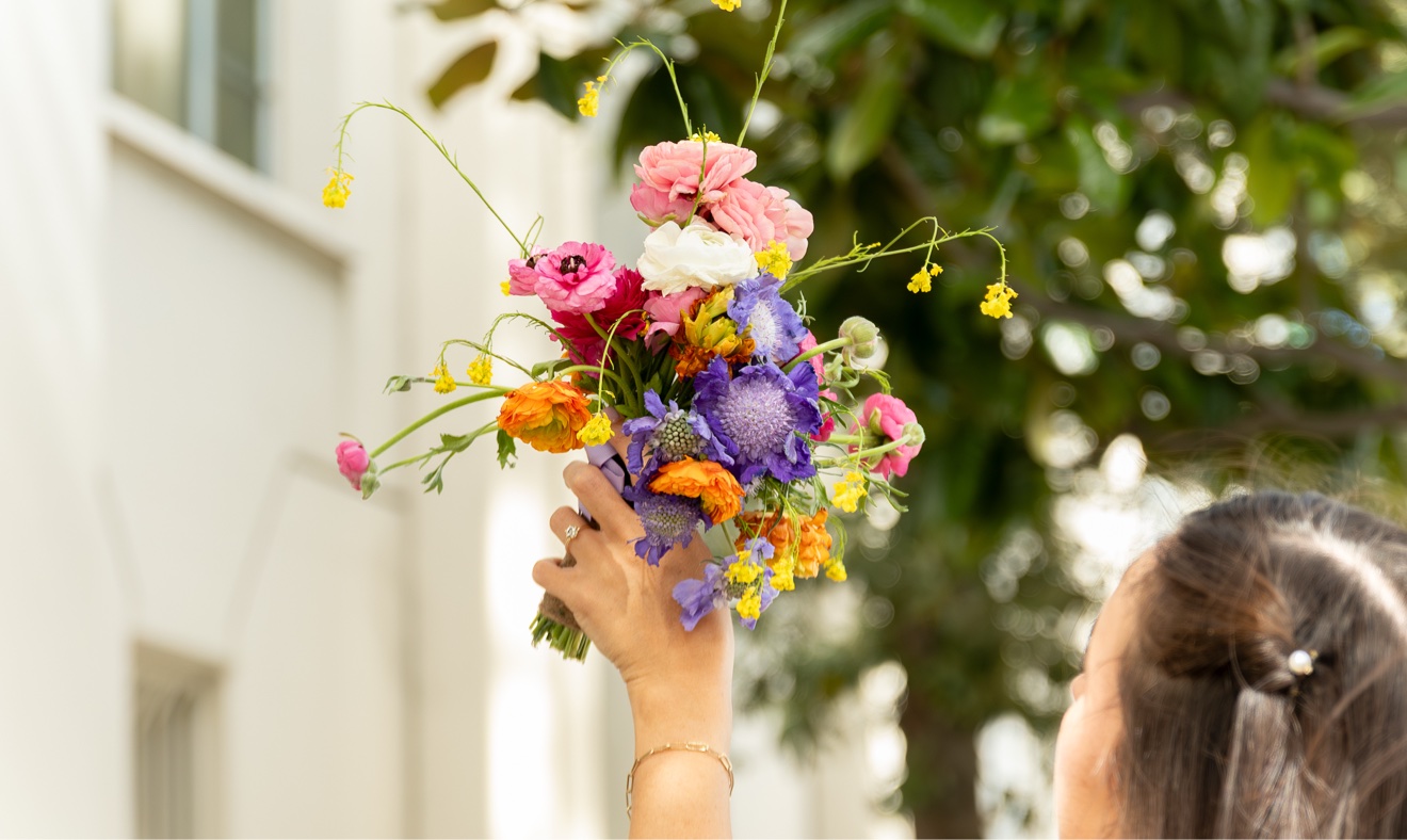 Vibrant garden-style bouquet with pink, orange, blue, and purple flowers