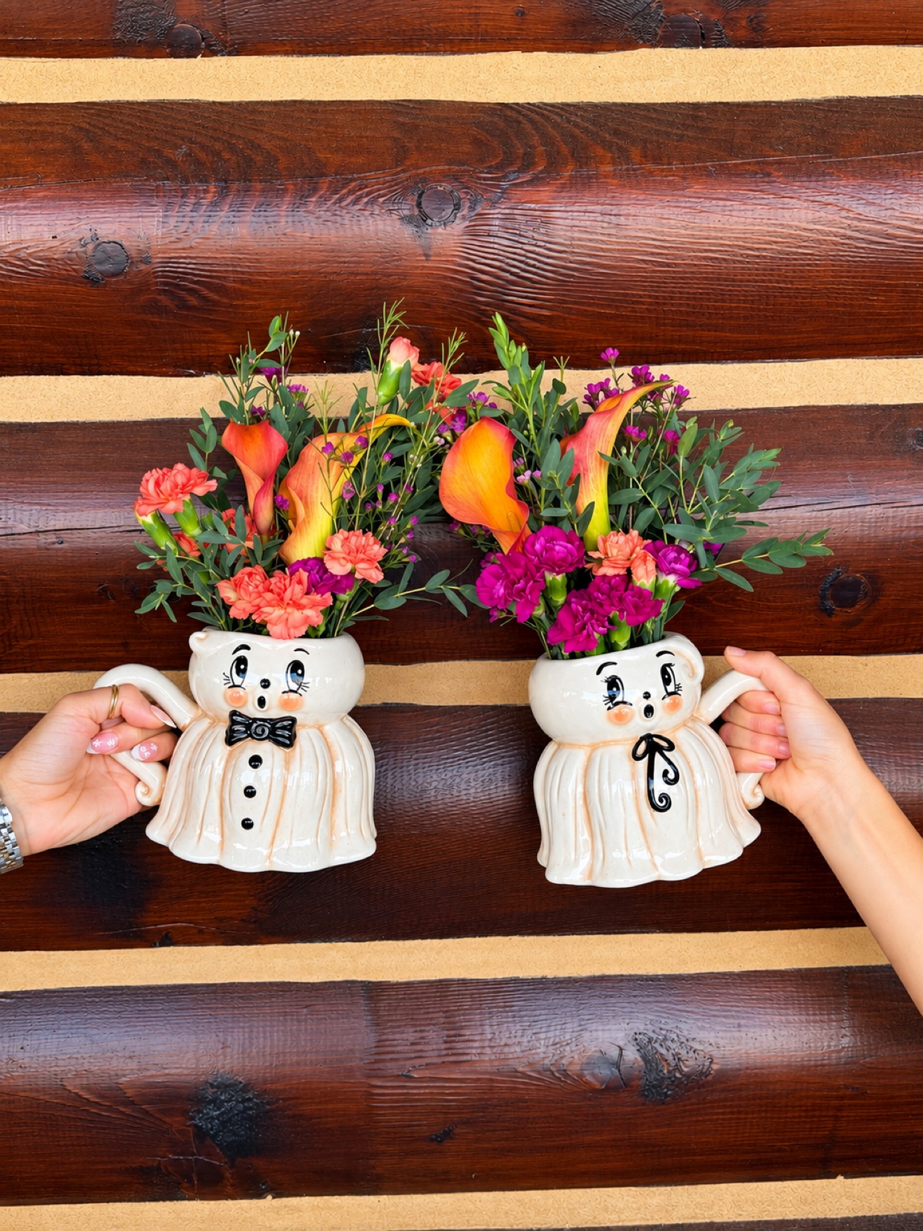 Ghost-shaped collector mugs filled with colorful fall flowers.