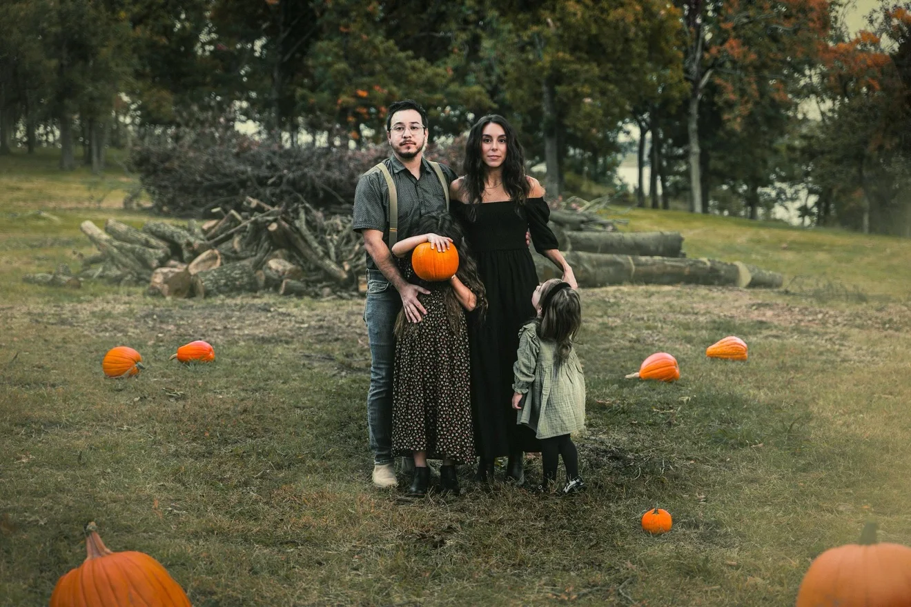 Bea and Alex with their two daughters among the pumpkins in autumn