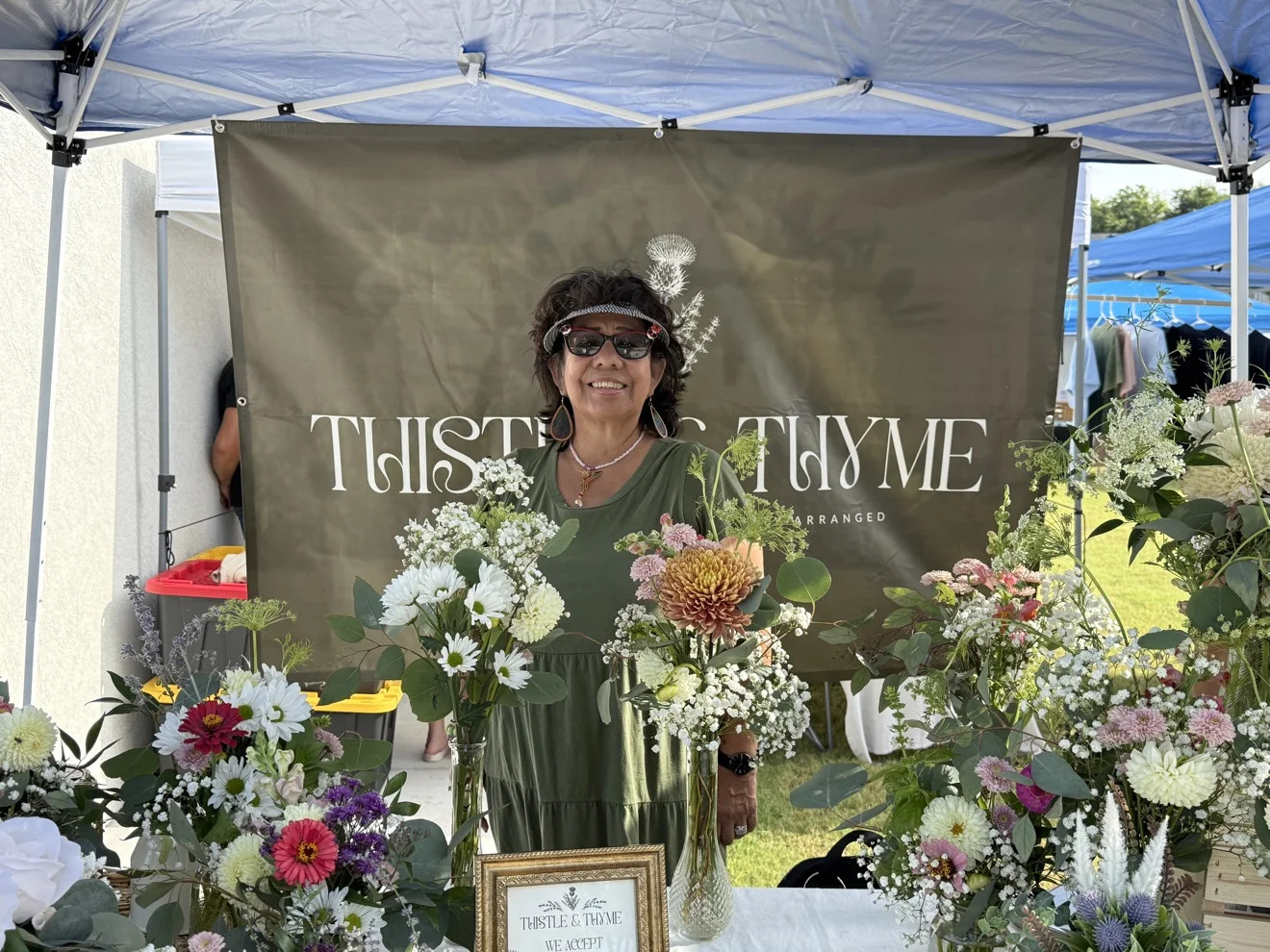 At the Thistle & Thyme market booth, surrounded by arrangements