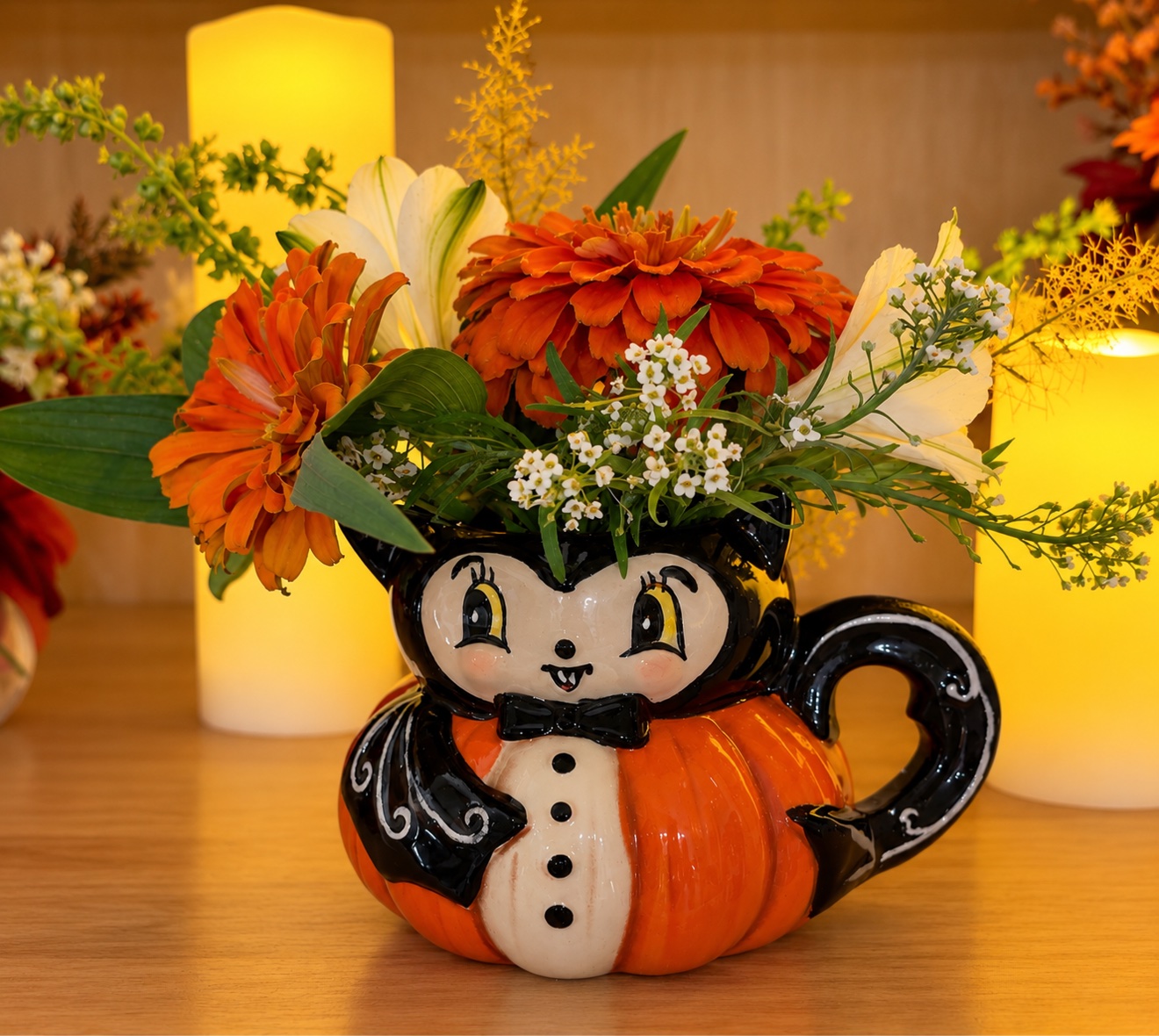 Halloween bat vase arrangement with orange zinnias and white lilies